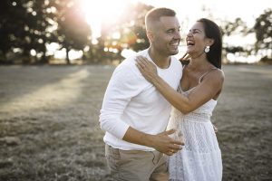 Una pareja comprometida riendo y divirtiéndose en el parque