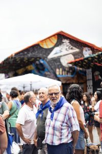 Gente celebrando la Aste Nagusia en Bilbao llevando puesto el pañuelo de fiestas con la baldosa de Bilbao.